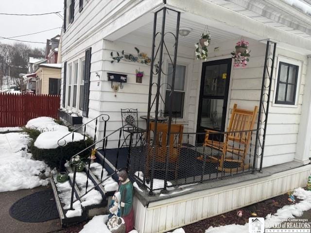 snow covered deck with a porch