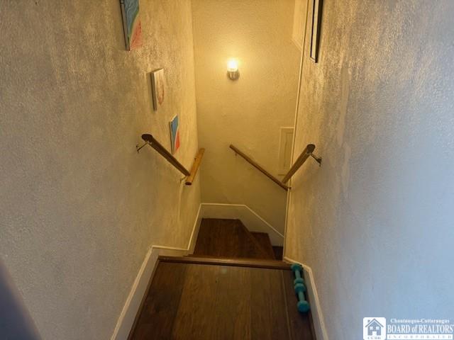 staircase with hardwood / wood-style floors