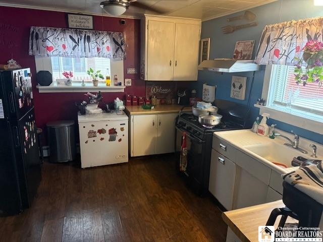 kitchen with dark hardwood / wood-style flooring, crown molding, sink, and black appliances