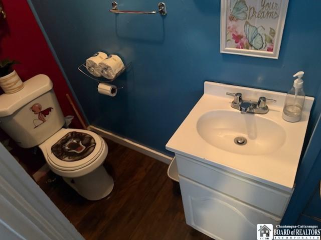 bathroom featuring wood-type flooring, vanity, and toilet