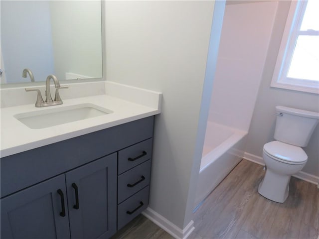 bathroom featuring hardwood / wood-style flooring, vanity, and toilet