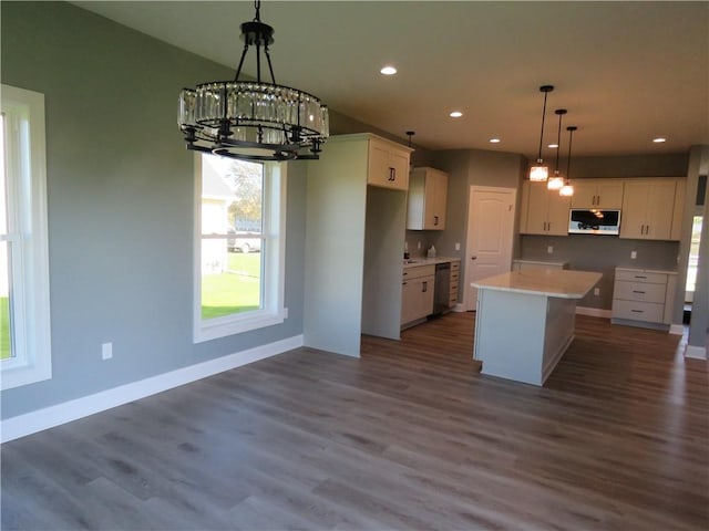 kitchen featuring stainless steel appliances, a kitchen island, dark wood-type flooring, and decorative light fixtures