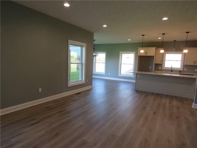 kitchen with white cabinetry, plenty of natural light, dark hardwood / wood-style floors, and decorative light fixtures