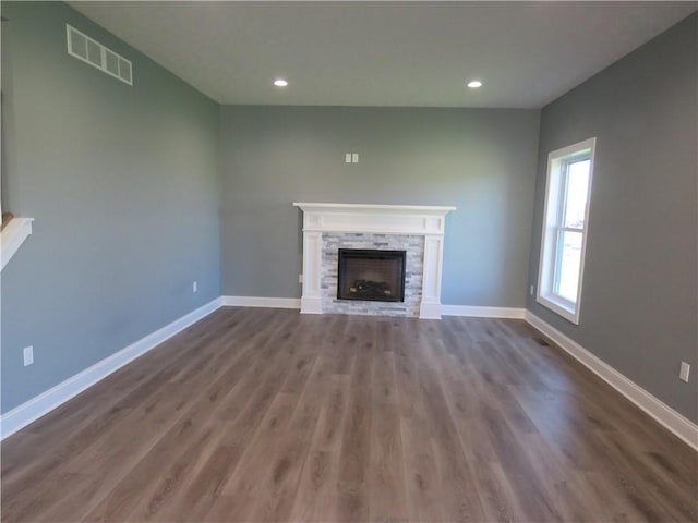 unfurnished living room featuring a fireplace and dark hardwood / wood-style flooring