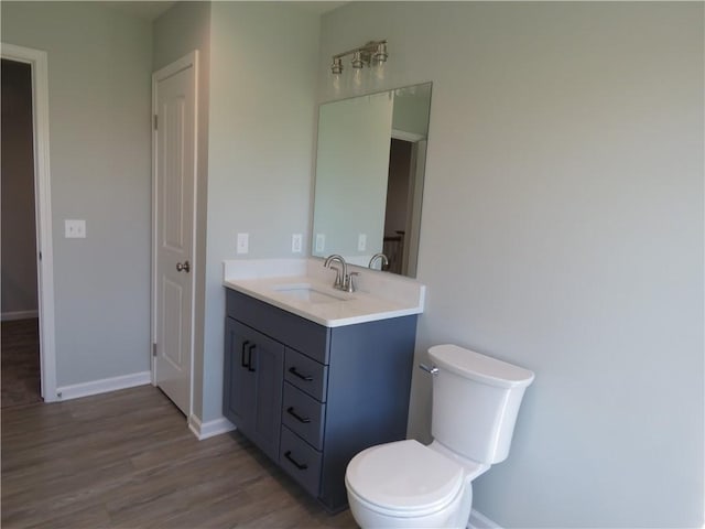 bathroom with vanity, toilet, and wood-type flooring