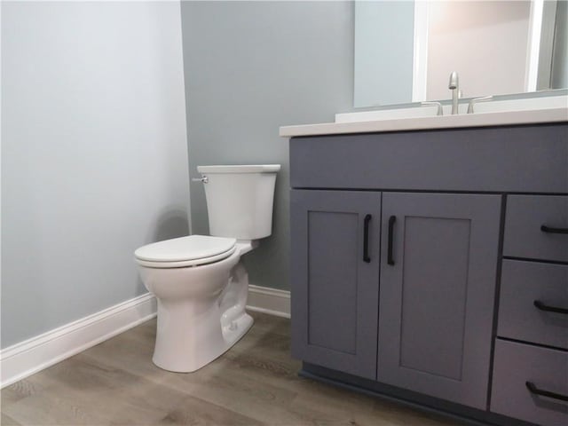 bathroom with vanity, toilet, and wood-type flooring