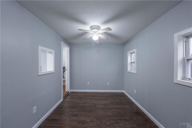 spare room with a textured ceiling, ceiling fan, and dark wood-type flooring