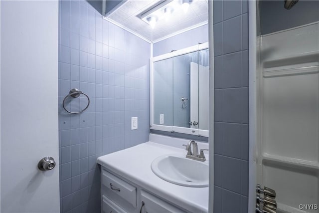 bathroom featuring vanity and tile walls