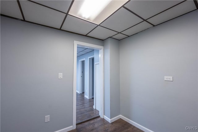 hall with a drop ceiling and dark hardwood / wood-style flooring