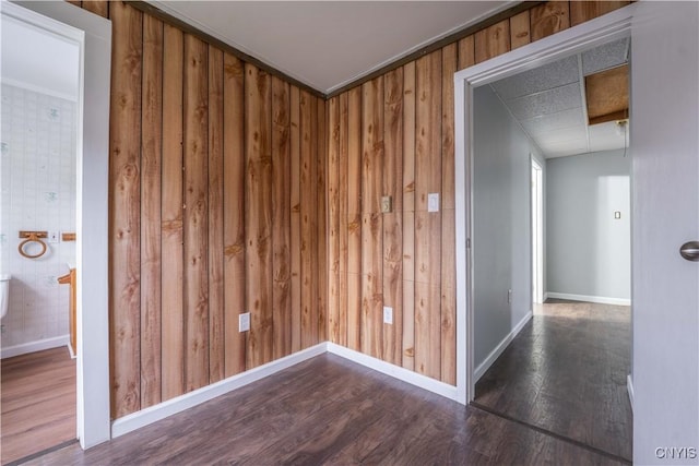 hallway featuring wood walls, dark hardwood / wood-style flooring, and crown molding