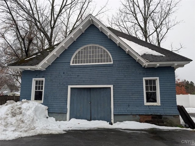 view of snowy exterior featuring a garage