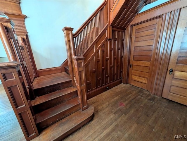 staircase featuring wood walls and hardwood / wood-style floors