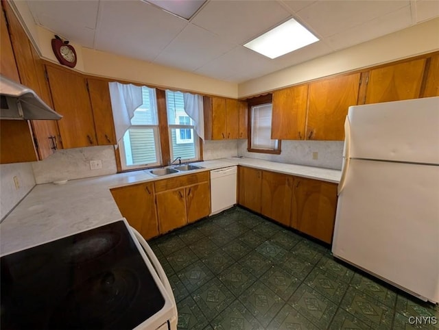 kitchen with decorative backsplash, white appliances, and sink