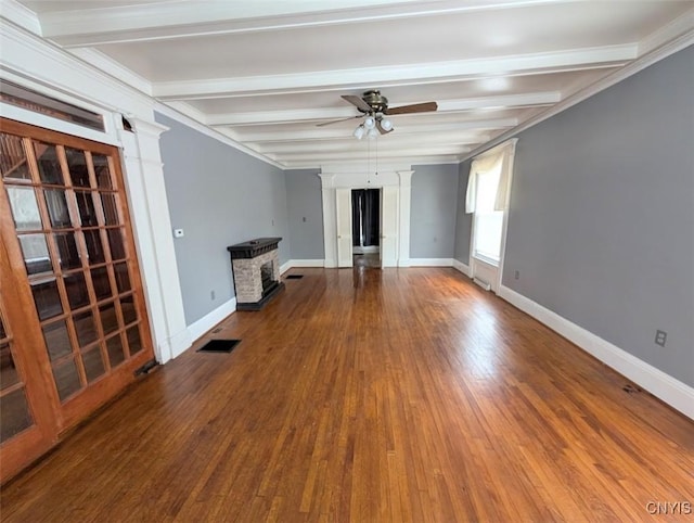 unfurnished living room featuring ceiling fan, hardwood / wood-style floors, beamed ceiling, and crown molding