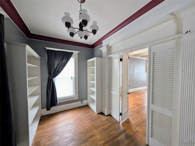 interior space featuring a chandelier, hardwood / wood-style floors, and crown molding