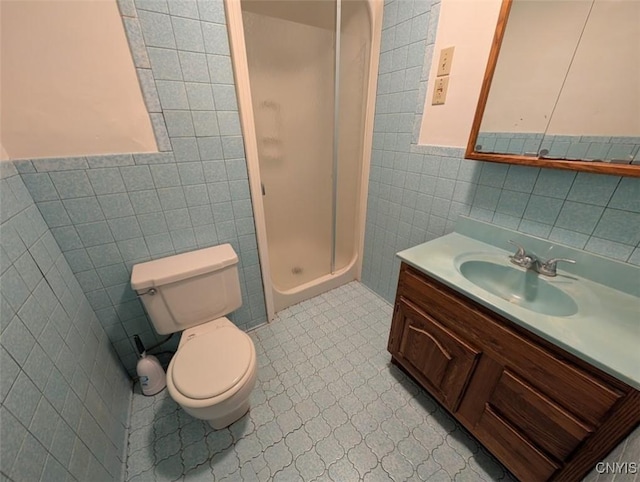 bathroom with tile patterned floors, walk in shower, vanity, tile walls, and toilet