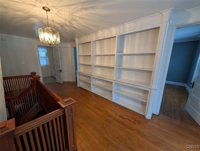 interior space with an inviting chandelier, ornamental molding, and hardwood / wood-style flooring