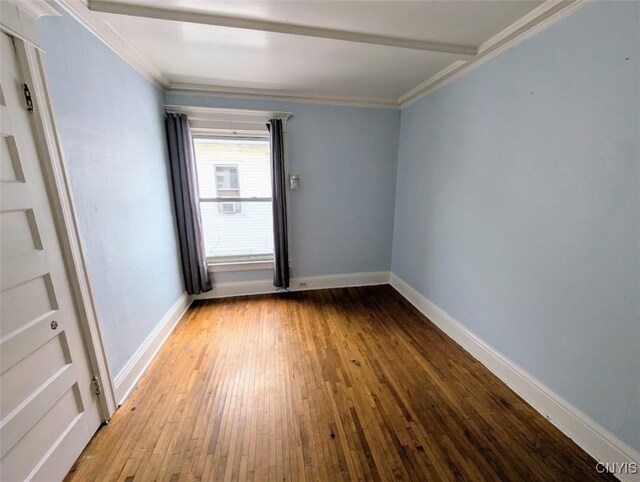 unfurnished room featuring hardwood / wood-style flooring and ornamental molding