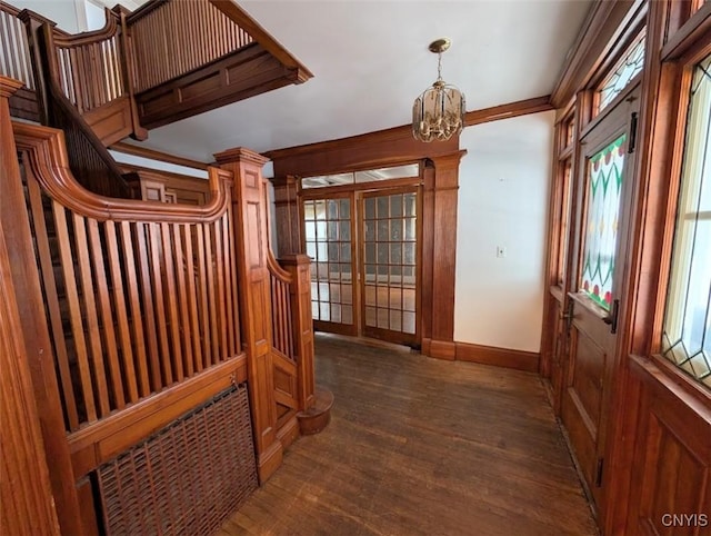 interior space with crown molding, dark wood-type flooring, and a notable chandelier