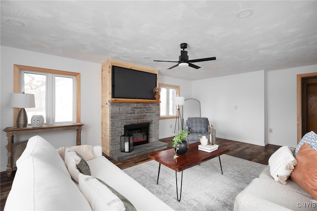 living room with a fireplace, dark hardwood / wood-style flooring, plenty of natural light, and ceiling fan