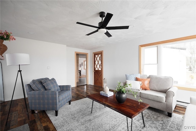 living room featuring dark hardwood / wood-style floors, a baseboard radiator, and ceiling fan