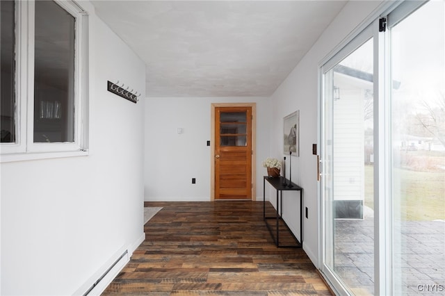 hall featuring plenty of natural light, dark hardwood / wood-style floors, and a baseboard heating unit