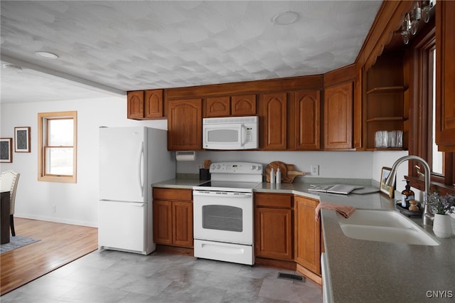 kitchen with wood-type flooring, white appliances, and sink