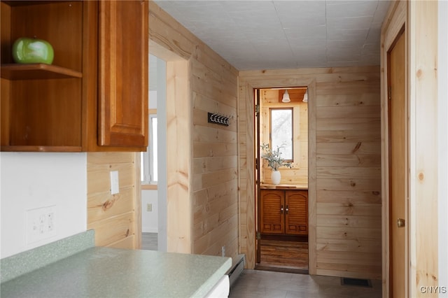 interior space with baseboard heating, a wealth of natural light, and wooden walls