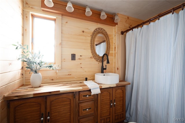 bathroom featuring vanity and wood walls