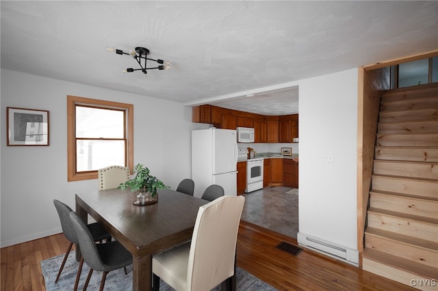 dining room featuring hardwood / wood-style floors, a textured ceiling, and a notable chandelier