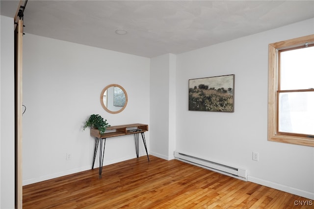 empty room with baseboard heating and light wood-type flooring