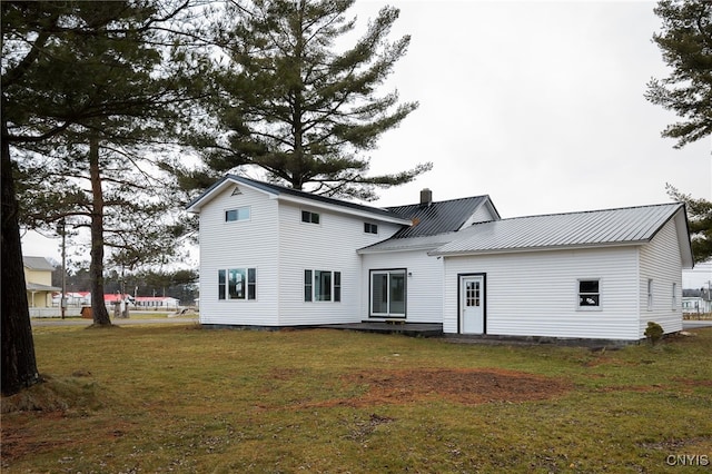 rear view of property featuring a lawn