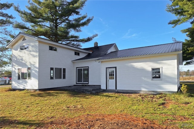 rear view of property featuring a lawn