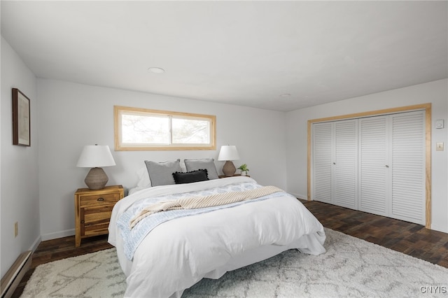 bedroom featuring dark hardwood / wood-style floors, a closet, and a baseboard radiator