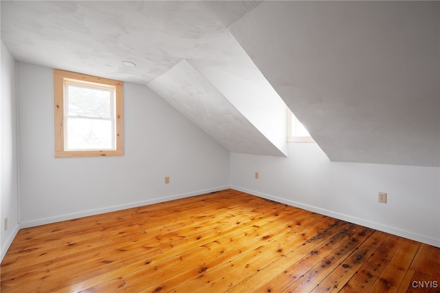 additional living space featuring hardwood / wood-style flooring and lofted ceiling