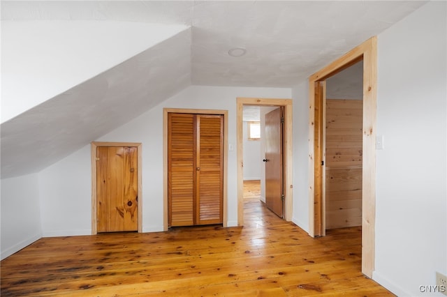 bonus room featuring lofted ceiling and wood-type flooring