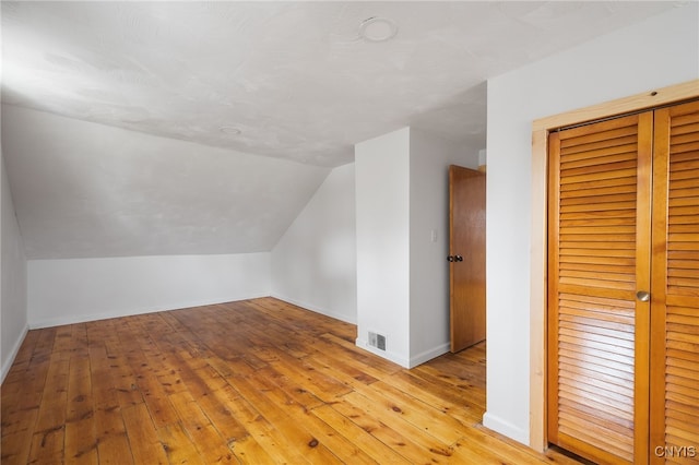 bonus room featuring lofted ceiling and light hardwood / wood-style flooring