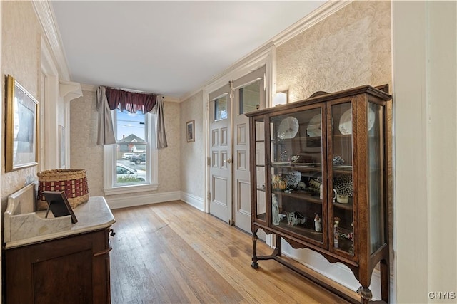 living area featuring light wood-type flooring and crown molding