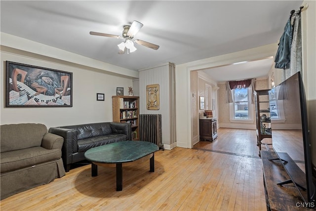 living room featuring radiator, ceiling fan, and light hardwood / wood-style flooring