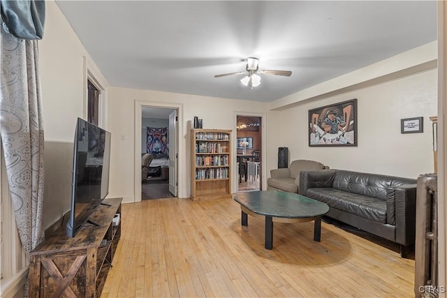 living room with ceiling fan and light hardwood / wood-style flooring