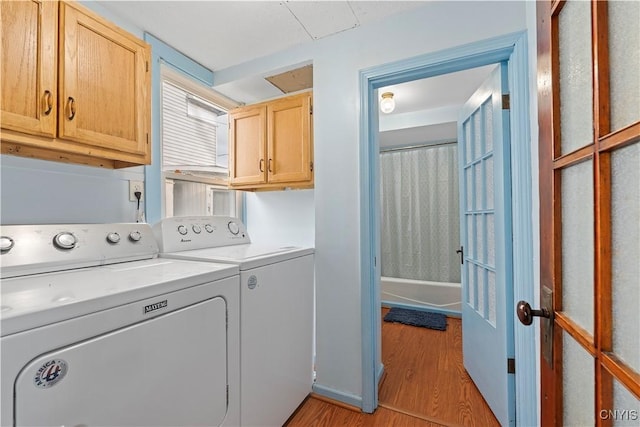 washroom featuring cabinets, light wood-type flooring, and washer and dryer