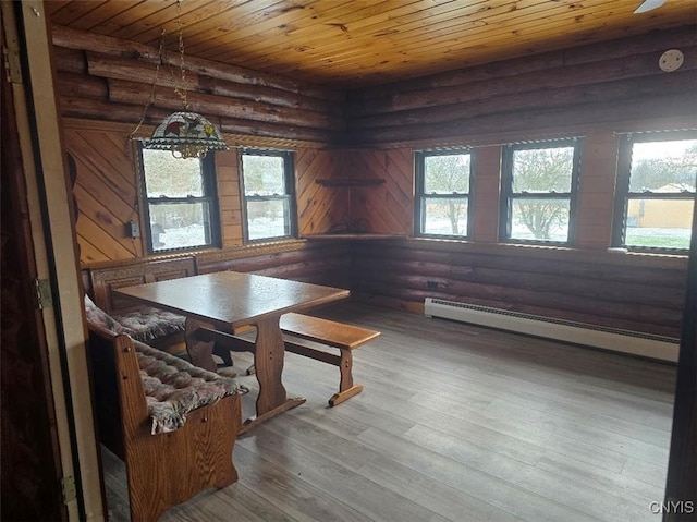 unfurnished dining area featuring wood-type flooring, rustic walls, and a healthy amount of sunlight