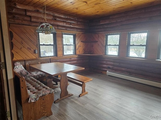 dining space with log walls, hardwood / wood-style flooring, plenty of natural light, and wooden ceiling