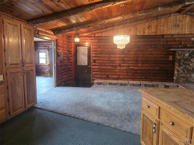 interior space with wood walls, dark carpet, wooden ceiling, lofted ceiling with beams, and a chandelier