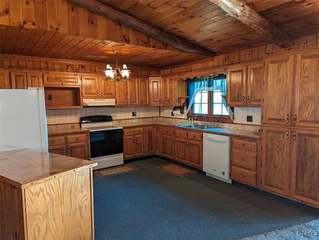 kitchen featuring white appliances, sink, dark colored carpet, pendant lighting, and a chandelier