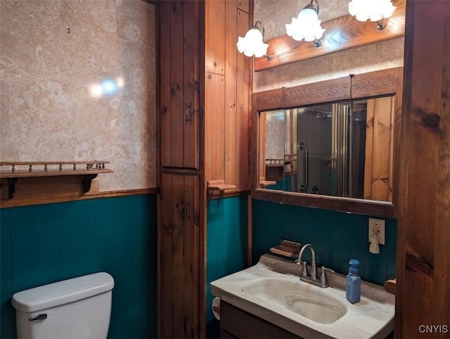 bathroom with wooden walls, vanity, and toilet