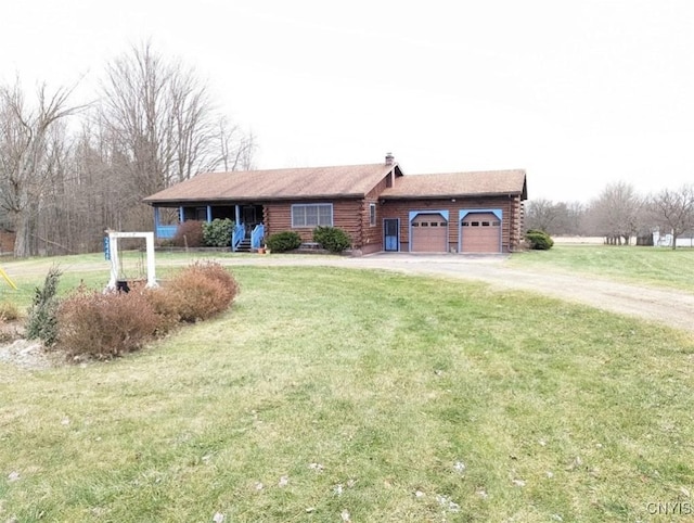 view of front of house featuring covered porch, a garage, and a front yard