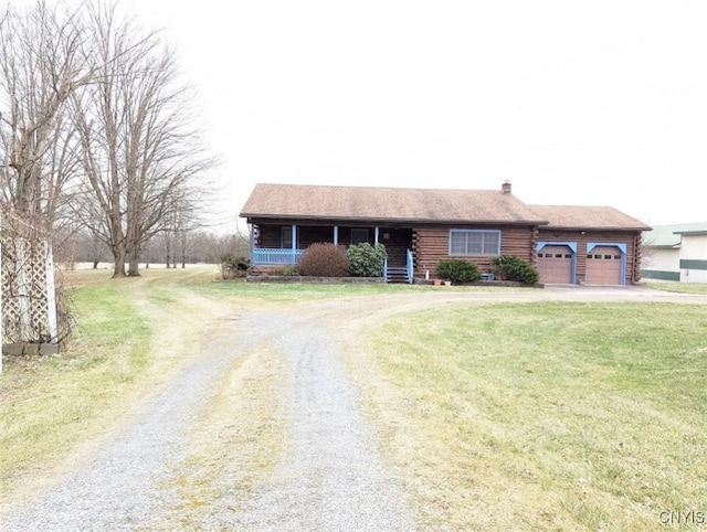 view of front of property featuring a front lawn, covered porch, and a garage