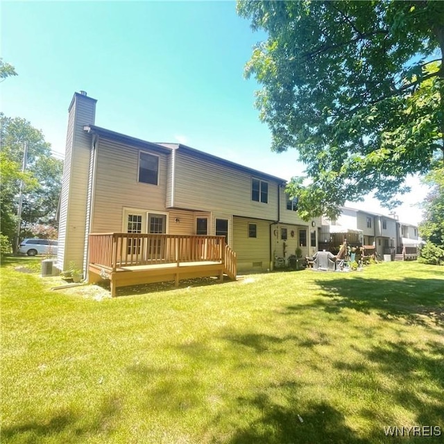 back of house featuring a lawn and a wooden deck