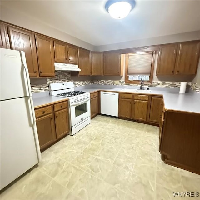 kitchen with backsplash, sink, and white appliances